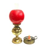 A brass oil lamp with glass chimney and red glass shade, 49cm high overall; together with a brass