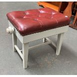 A late 19th/early 20th century adjustable piano stool, button upholstered red leather seat, on a