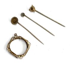 A 15ct gold stick pin, 1.4g; together with a 9ct sovereign mount, 1.6g; a fox mask stick pin and one