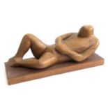 A carved wooden sculpture of a reclining figure, 47cmW