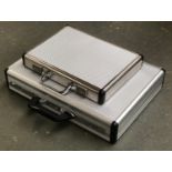 Two metal flight case style attache cases, the larger 46cmW