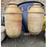 A pair of terracotta olive jars on wrought iron stands, 91cmH