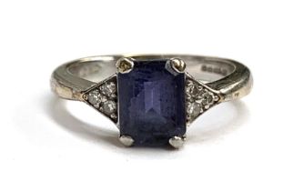 A 9ct white gold ring set with an emerald cut iolite with three small diamonds either side, 3.6g,