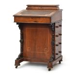 A Victorian walnut davenport desk, with moulded superstructure and hinged writing slope, four side