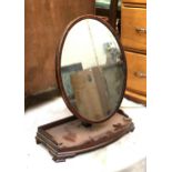 A 19th century oval shaving mirror, on bowfront galleried stand, 58cmH; together with an oval