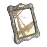 A large Art Nouveau chased silver photo frame by W J Myatt & Co, Birmingham 1915, Rd. number 433939,