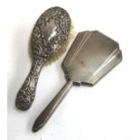 An early 20th century hairbrush with chased silver back, together with an engine turned silver Art