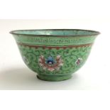 A Chinese canton enamel bowl (af), flowers on a green ground, 11cmD