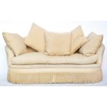 A contemporary Peter Dudgeon serpentine shaped sofa, upholstered in a yellow striped fabric, feather