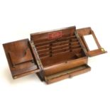An early 20th century oak stationery box, opening to a letter rack, embossed leather plaque