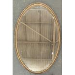 A large oval mirror with bevelled glass, in gilt gesso frame, 102x66cm