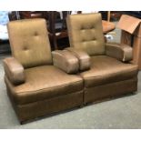 A pair of unusual mid century armchairs in the style of cinema seats, each with hinged arms,