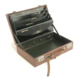 A gent's brown leather overnight or attache case, green morocco interior with document wallets,