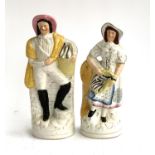 A pair of 19th century Staffordshire flatback figurines, a man and lady holding baskets of fish,