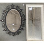 A small long mirror in a white painted frame, 67x32cm, together with a further oval mirror in