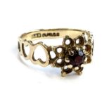 A 9ct gold and garnet ring of floral openwork form, the shank with heart designs, size L, 1.6g