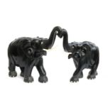 A pair of two very large and heavy African carved ebony elephants, both with multiple historic