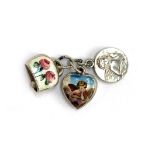 A silver and enamel puffy heart charm depicting Raphael's cherub, 1cmW; together with a similar