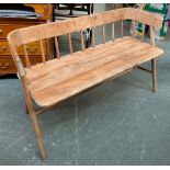 A 20th century stick back bench, with curved rail over a three plank seat, legs joined by H