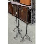 A trio of wrought iron adjustable standard lamps, each approx 122cmH