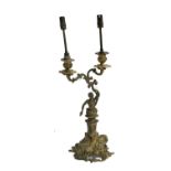 A French gilt metal two arm table lamp, in the form of a Classical man, on a Rococo style base,