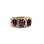 A 9ct gold garnet trilogy ring set with four small diamonds, size Q 3/4, 3.4g