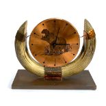 A vintage German Kienzle copper and resin horn mantle clock decorated with an image of a hippo,