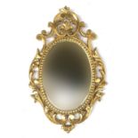 A 20th century decorative pierced gesso framed mirror with oval plate, 75cmH