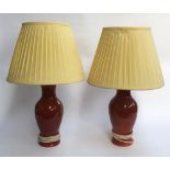 A pair of brick glazed baluster form table lamps with yellow pleated shades, 65cmH to top of shade
