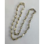 An early 20th century mother of pearl teardrop shaped balamuti bead necklace, 88cmL unclasped