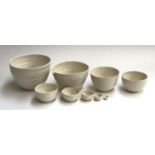A set of nine graduating studio pottery finely turned bowls, the largest 22cmD, the smallest 2.3cmD,