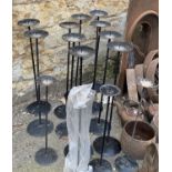 Fourteen metal candlestick holders, the taller 75cmH