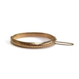 A 9ct gold bangle, engraved with foliate design, hallmarked Birmingham 1919, 9.6g