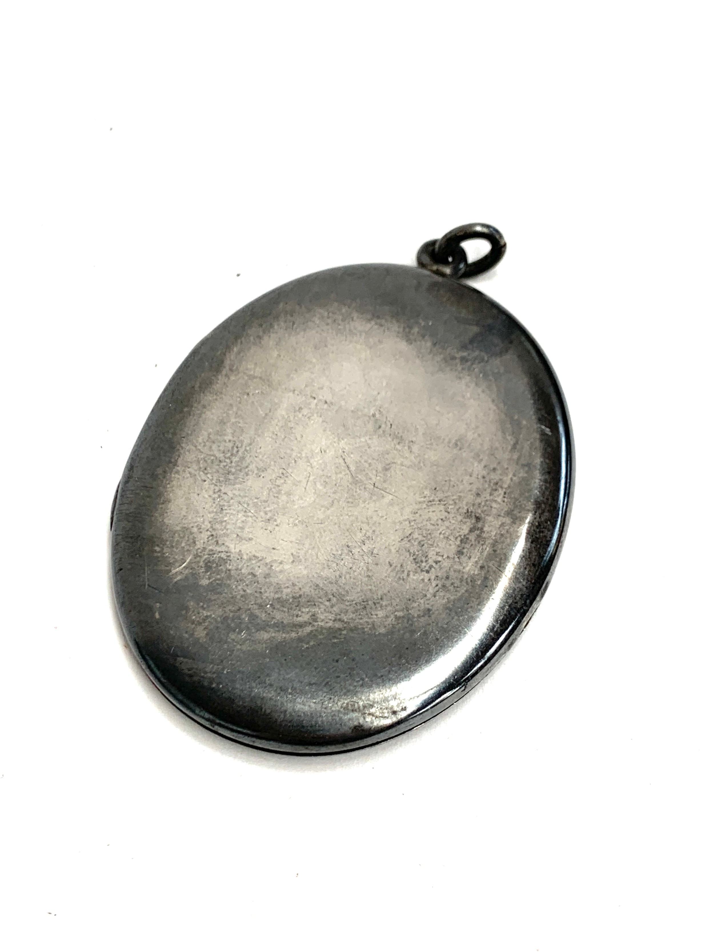 A large oval silver locket, marked 'STERLING', 7cm high