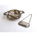 A George V silver tea strainer by Thomas Bradbury & Sons Ltd, Sheffield 1915; together with a '