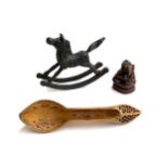 A small cast iron model of a rocking horse, 14cmH; together with a carved and pierced wooden spoon