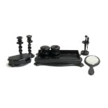 An ebony treen dressing table set, comprising inkwell, screw top jar, looking glass, candlesticks