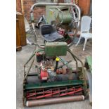 An Atco petrol lawnmower with Briggs & Stratton engine and seat with roller