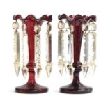 A pair of 19th century cranberry glass table lustres, each with eight cut glass pendants, on tapered