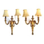 A pair of giltwood two arm wall sconces, each with ram mask detail and bell flower swags, with