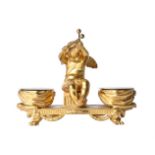 A French gilt-metal inkstand in 19th century style, modelled as a putto playing kettle drums, the