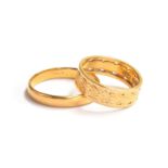 Two 22ct gold bands, the larger plain band size Q 1/2, 3.2g, the smaller band with pierced detail,