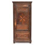 An 18th century French provincial oak cupboard, moulded pediment over a single inlaid door opening