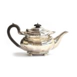 An Edwardian silver teapot, Chester 1907, the rim chased with grape and vine, faceted body, on bun
