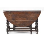 A late 17th/early 18th century oak gateleg table, the oval top on baluster turned supports joined by