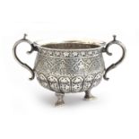 An Indian silver twin handled sugar bowl, the half gadrooned body allover chased with foliate