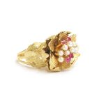A heavy 18ct gold ring in the form of a naturalistic flower head, set with a cluster of pearls and