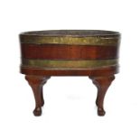 An oval mahogany wine cooler, 18th century and later, staved construction on four cabriole legs,