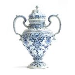 An 18th century large Delft twin handled urn with cover, decorated with swirling florals, marked