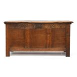 An early 18th century oak three panel coffer, demilune carved frieze, with panelled sides, 128cm